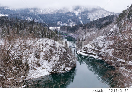 【只見線】冬景色の第一只見川橋梁を走行する列車 123543172