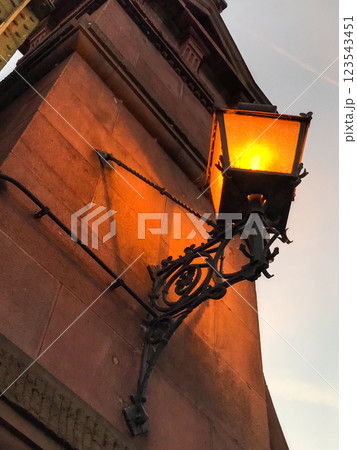 An old lantern glows on the wall at dusk 123543451