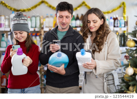 Couple man and woman with daughter scanning qr code for detergent 123544419