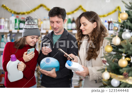Family checking expiration date of detergent using smartphone 123544448