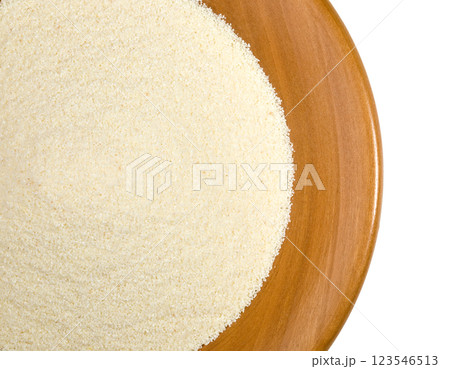 Raw semolina flour in a wooden bowl filling the frame Raw semolina flour in a wooden bowl filling the frame 123546513