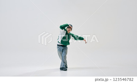 Hip-hop dancer, dressed stylish vintage jacket and jeans, smoothly transitioning between moves against white studio background. 123546782