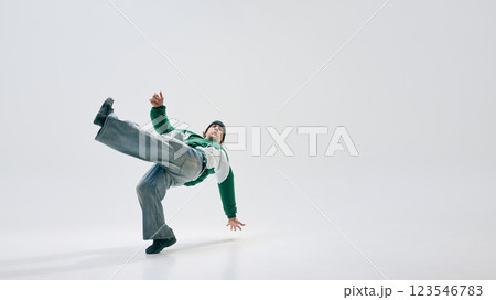 Male freestyle dancer executing powerful freeze with body twisted in motion against white studio background. Concept of sport 123546783