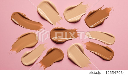 Variety of foundation swatches on pink background for beauty and skincare concepts 123547084