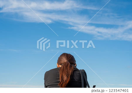 空を見て黄昏れる若い女性 123547401
