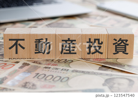 お金の上に不動産投資と書かれたブロック お金の上に不動産投資と書かれたブロック 123547540