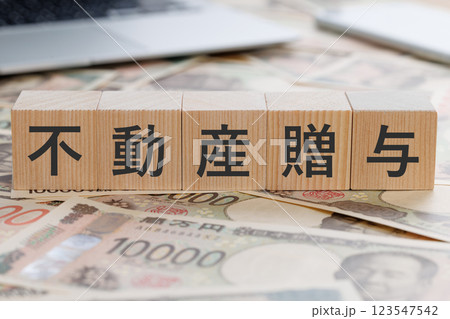 お金の上に不動産贈与と書かれたブロック 123547542