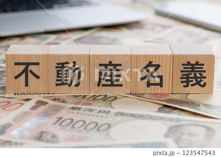 お金の上に不動産名義と書かれたブロック お金の上に不動産名義と書かれたブロック 123547543