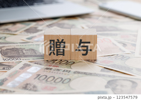 お金の上に贈与と書かれたブロック 123547579