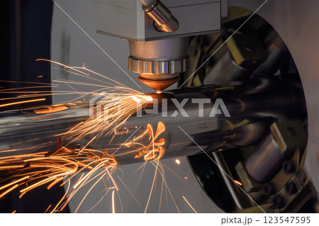 Close up scene the fiber laser cutting machine cut the stainless steel tube and sparkling light. 123547595