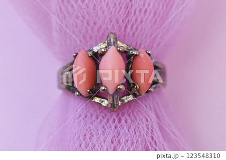 Statement ring for women on a pink background, fine jewelry concept, promotional photo for an online vintage and handmade jewelry store Statement ring for women on a pink background, fine jewelry concept, promotional photo for an online vintage and handmade jewelry store 123548310