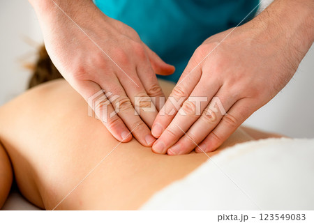 Massage therapist doing massage of trigger points in the back Massage therapist doing massage of trigger points in the back 123549083