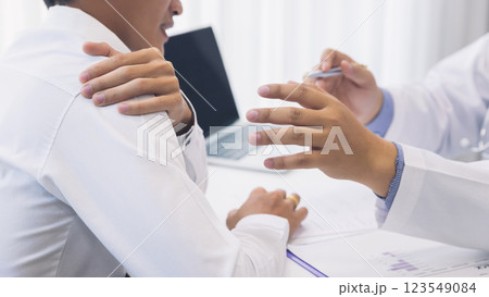 Doctor examining a patient suffering from shoulder pain. Doctor examining a patient suffering from shoulder pain. 123549084