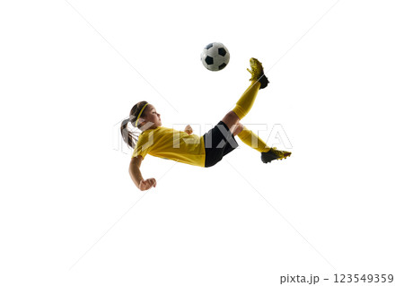 Dynamic image of competitive child, girl in uniform, playing soccer game, hitting ball in motion and falling down against white studio background Dynamic image of competitive child, girl in uniform, playing soccer game, hitting ball in motion and falling down against white studio background 123549359