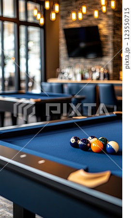 Blue billiard table set with white balls creates an inviting atmosphere in a lively bar, perfect for socializing and gameplay 123550715