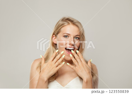 Happy surprised excited woman. Female model with blond hairstyle and clean skin, facial treatment 123550839