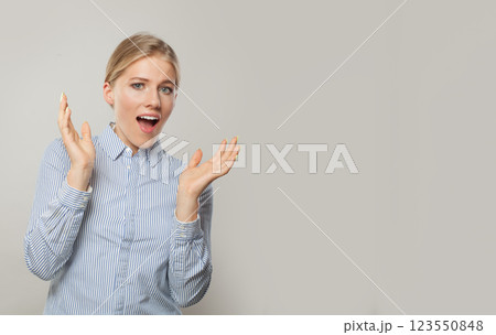 Happy surprised business woman looking at camera with open mouth on grey background with copy space Happy surprised business woman looking at camera with open mouth on grey background with copy space 123550848