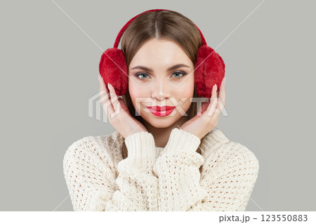 Cheerful woman wearing red fluffy ear muffs, fashion beauty portrait 123550883