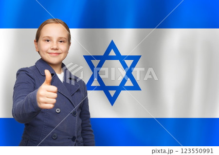 Smiling child holding thumb up with Israeli flag background 123550991