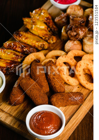 Assorted grilled meat appetizers on wooden board, top view. 123551584
