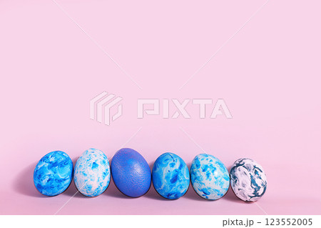 Decorated blue easter eggs on a pink background. Minimal holiday concept. Happy easter background. Creative painting of eggs at home, the idea of simple drawings for coloring 123552005