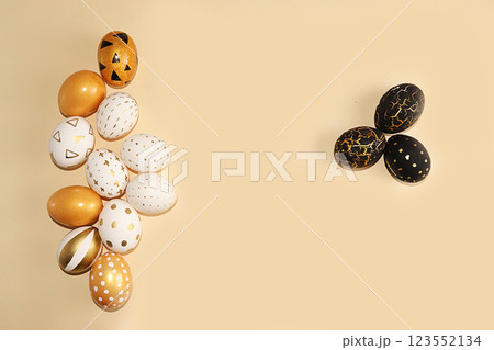 Decorated golden easter eggs on a yellow background. Minimal holiday concept. Happy easter background. Creative painting of eggs at home, the idea of simple drawings for coloring, a place for text, a 123552134