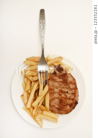Roast pork loin with fried potatoes. Delicious meat breakfast. French fries. Roast pork loin with fried potatoes. Delicious meat breakfast. French fries. 123552161