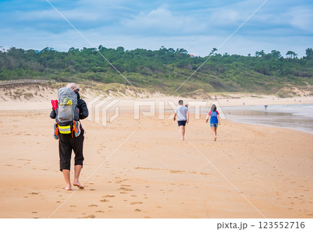 Pilgrim with backpack going on beach on the North way Camino de Santiago, Spain Pilgrim with backpack going on beach on the North way Camino de Santiago, Spain 123552716