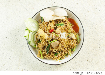 fried noodles with fried egg topping, meatballs, shredded chicken, home made indonesian food, white marble texture table isolated fried noodles with fried egg topping, meatballs, shredded chicken, home made indonesian food, white marble texture table isolated 123553274