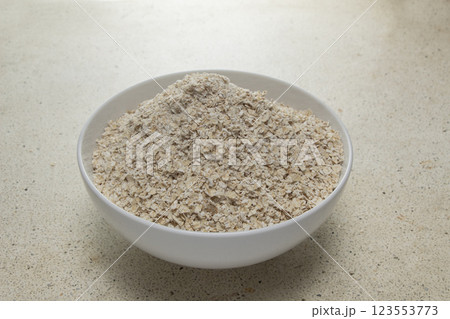 You can see the top corner of full oats in a clean white bowl on the table 123553773