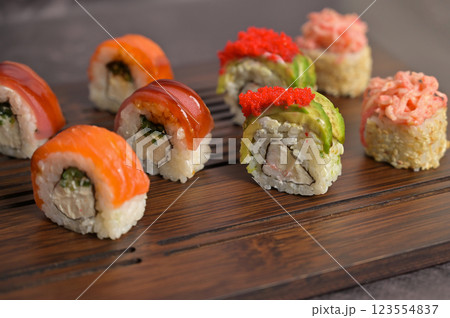 Set of sushi roll with rice and fish on wooden serving board. Dark black texture background with copy space. Close up. Japan menu. Asian food 123554837