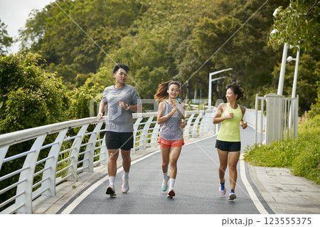 young asian adults running jogging outdoors young asian adults running jogging outdoors 123555375