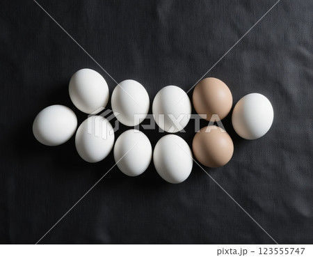 White and brown eggs arranged on a black background. 123555747