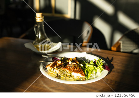 Healthy baked zucchini galette tart. Piece of homemade vegetable tart with cheese, herbs and zucchini on the table. Vegetarian food. 123556450