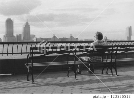 990年代ニューヨーク・マンハッタン・バッテリーパークでベンチに座りハドソン川見つめる中年の白人男1 123556512