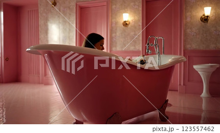 Woman relaxing and reading a book in pink bathtub 123557462