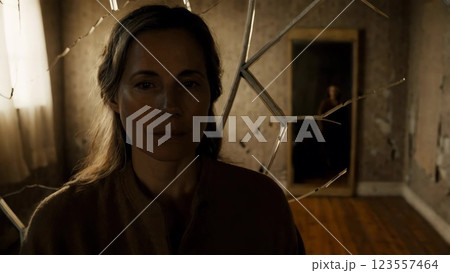 Woman staring with concerned expression, mysterious figure reflecting in mirror 123557464