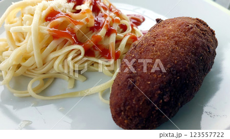 Savory Delight of Pasta and Cutlet on a White Plate During a Sunny Afternoon 123557722