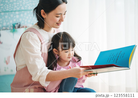 園児に絵本を読み聞かせる保育士 123558111