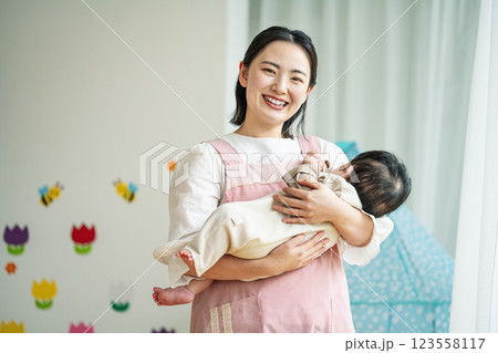 0歳児保育士として働く若い女性 123558117