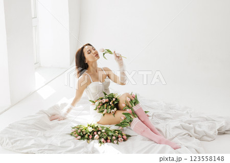 Elegant woman in white lingerie lying on bed with tulips, enjoying flowers in soft natural light, romantic and feminine aesthetic Elegant woman in white lingerie lying on bed with tulips, enjoying flowers in soft natural light, romantic and feminine aesthetic 123558148