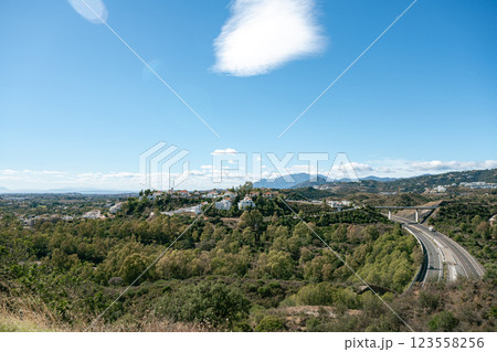 Scenic view of countryside landscape with road and hills under blue sky 123558256