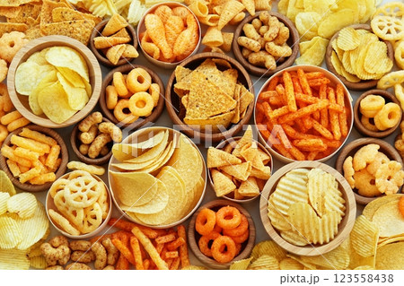 Colorful mix of salty snacks for beer varieties: chips and pretzels, onion rings and crackers. Non-healthy junk food background Colorful mix of salty snacks for beer varieties: chips and pretzels, onion rings and crackers. Non-healthy junk food background 123558438