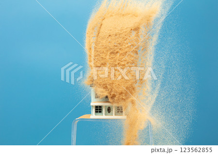 Sand storm hit House as natural disaster from climate change global warming. Strong wind of sand attack house with insurance create loss damage environment. Blue background isolated Sand storm hit House as natural disaster from climate change global warming. Strong wind of sand attack house with insurance create loss damage environment. Blue background isolated 123562855
