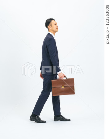 カバンを持って歩くミドルエイジ男性ビジネスパーソンの後ろ姿の全身写真 カバンを持って歩くミドルエイジ男性ビジネスパーソンの後ろ姿の全身写真 123563008