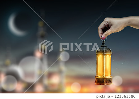 Muslim man holding traditional glowing Arabic lantern with blurred of mosque with crescent moon. Copy space or mockup. Concept of Eid Al Fitr and Ramadan Mubarak. Ramadan kareem background Muslim man holding traditional glowing Arabic lantern with blurred of mosque with crescent moon. Copy space or mockup. Concept of Eid Al Fitr and Ramadan Mubarak. Ramadan kareem background 123563580