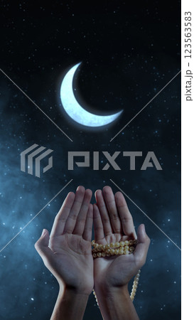 Muslim man praying with prayer beads and a crescent moon in the night scene background. Copy space or mockup. Concept of Eid Al Fitr and Ramadan Mubarak. Ramadan kareem background Muslim man praying with prayer beads and a crescent moon in the night scene background. Copy space or mockup. Concept of Eid Al Fitr and Ramadan Mubarak. Ramadan kareem background 123563583