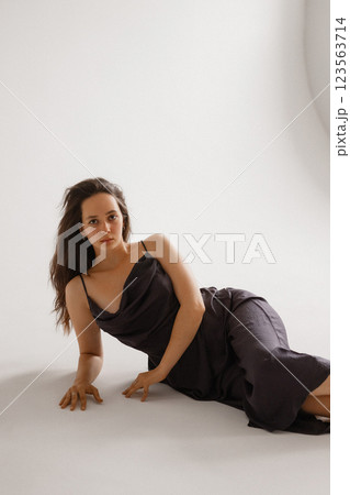 Elegant Woman in a Dark Slip Dress Posing on a White Background Elegant Woman in a Dark Slip Dress Posing on a White Background 123563714