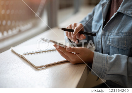A person looking at the smartphone holding in left hand with right hand pointing at the screen. A person looking at the smartphone holding in left hand with right hand pointing at the screen. 123564260
