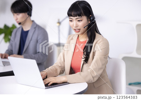 ビジネス コールセンターで働く若い男女 ビジネス コールセンターで働く若い男女 123564383